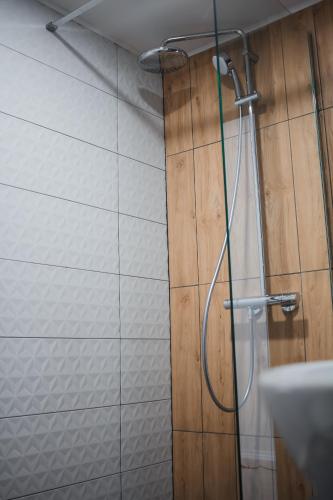 a shower with a hose attached to a wall at MOUNTAINS HUT in Mykulychyn