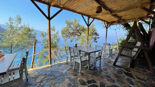 a restaurant with tables and chairs and a view at Kabak Ütopya Suites in Faralya