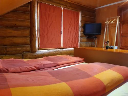 two beds in a room with a window and a television at Magasbükk Drakula Kulcsosház Ivó in Izvoare