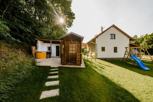 a small house with a slide and a playground at Na Želivce chalupa Gabriela in Želiv