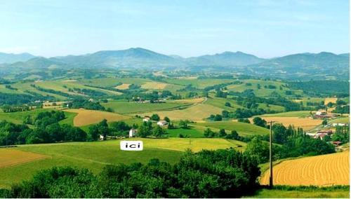 a view of a green field with mountains in the background at Maison confortable à Bardos avec vue sur montagne in Bardos