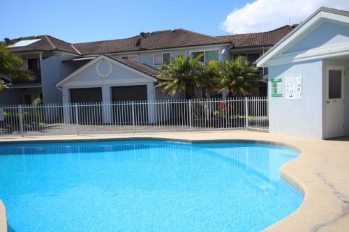 a swimming pool in front of a house at Paradise Waters 13 in Coffs Harbour