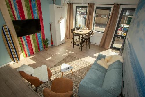 a living room with a blue couch and chairs at Bed & Breakfast Bakker Meijer in Heemskerk