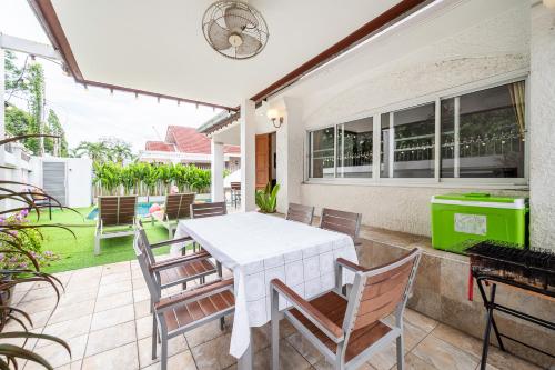 an outdoor patio with a white table and chairs at Wongamart Pool Villa in North Pattaya