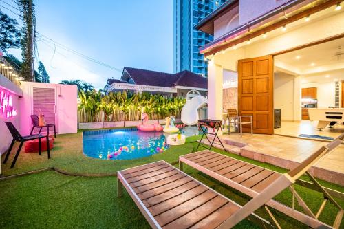 a backyard with a swimming pool and a house at Wongamart Pool Villa in North Pattaya