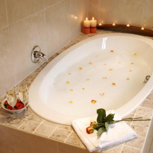 Una bañera en un baño con velas. en Sacred Mountain Lodge, en Noordhoek