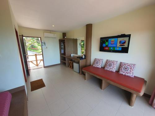 a living room with a red bench with pillows on it at Moonstone Studio in Haad Rin