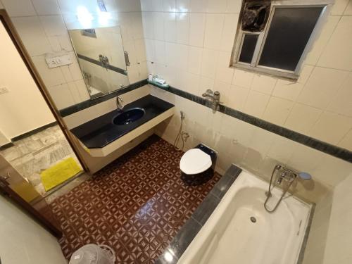 a bathroom with a sink and a toilet and a tub at GT Grande Hotel-Near US Consulate in Chennai