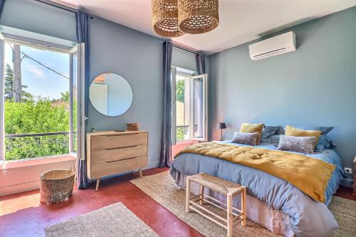 Schlafzimmer mit blauen Wänden, einem Bett und einem Spiegel in der Unterkunft La Maison in Istres