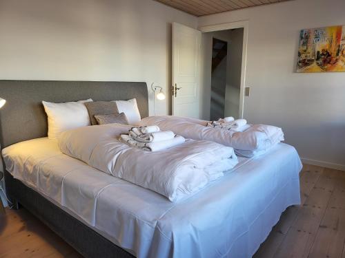 a large bed with white sheets and towels on it at City Harbour House in Sønderborg