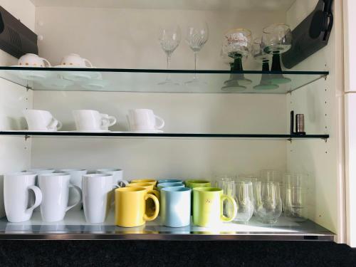 a shelf filled with cups and mugs and glasses at brauHAUS in Forchheim