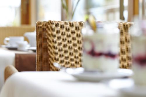 a table with wicker chairs and a plate of food at Hotel Klingler in Maurach