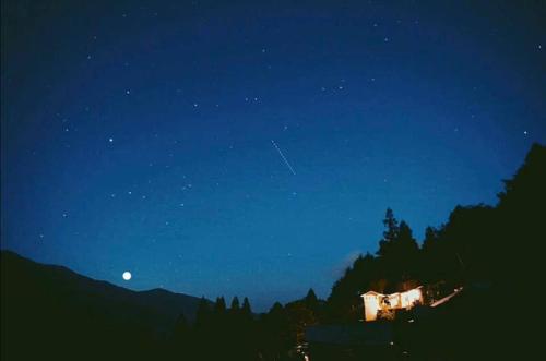a night view of a house with the moon in the sky at Guesthouse boro-ya in Otoyocho