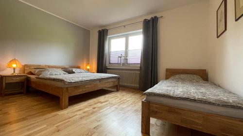 sypialnia z 2 łóżkami i oknem w obiekcie Fischers Nordseehaus Bungalow mit Garten w mieście Wilhelmshaven