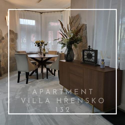 a dining room with a table and a vase of flowers at Apartment Villa Hřensko 132 in Hřensko