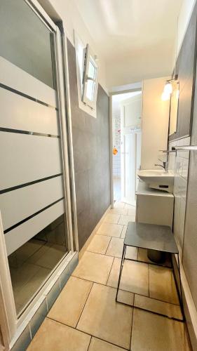 La petite salle de bains est pourvue d'un lavabo et de carrelage. dans l'établissement Appartement à quelques pas de la plage avec jardin, à Merlimont