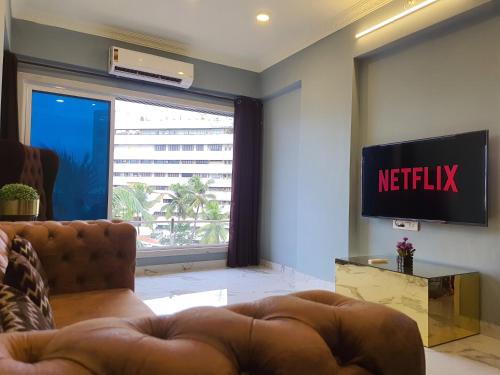 a living room with a couch and a television at OSI Apartments Lilavati Bandra in Mumbai