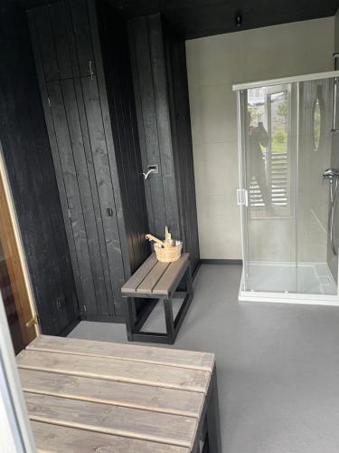 a bathroom with a shower and a bench and a shower stall at Mano jura 2-Apartments in Palanga