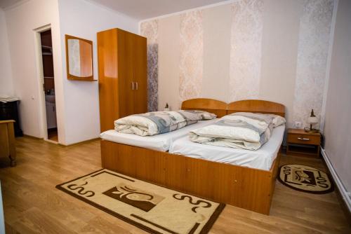 HOTEL MARION POIANA في Dumbrăveni: غرفة نوم مع سرير مع لوح خشبي للرأس