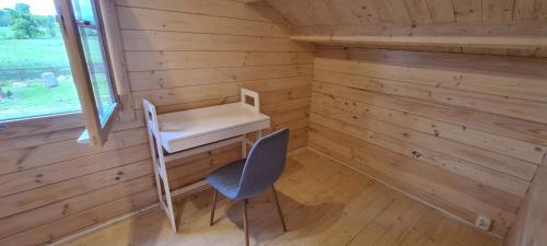 a tiny house with a desk and a chair at Domek z Sauną i balią jakuzii w głuszy in Borzynowo