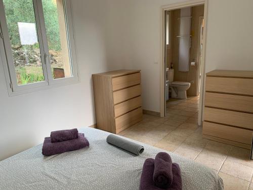 - une chambre avec un lit et des serviettes pourpres dans l'établissement Villa greoux, à Gréoux-les-Bains