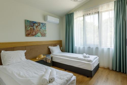 a hotel room with two beds and a window at Kraimorie Park in Burgas