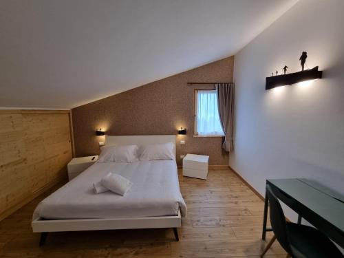 a bedroom with a white bed and a window at Rifugio Baita Motti in Domodossola