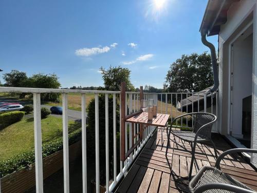 a deck with a table and chairs on a balcony at favstay Industrialstyle 2-Zimmer 60qm mit Balkon, Panarbora Fernblick, 55" TV & Netflix, 55Mbit WLAN, Parkplatz in Waldbröl