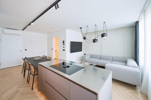 eine Küche und ein Wohnzimmer mit einem Tisch und einer Couch in der Unterkunft NEU RESIDENCES smart stay in Ljubljana