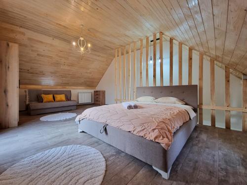 a bedroom with a large bed in a wooden ceiling at Apartmani Gala Žabljak in Žabljak