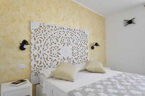 una camera da letto con un letto bianco e una parete di Appartamento vista Golfo a Cala Gonone
