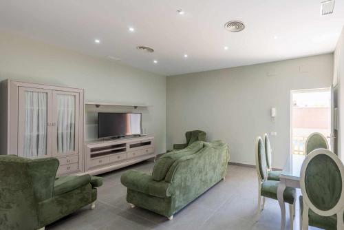 a living room with two chairs and a television at Apartamento Torero II in Marchena