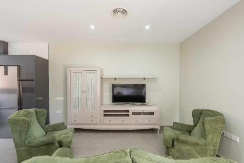 a living room with two chairs and a television at Apartamento Torero II in Marchena