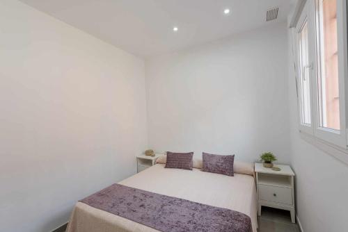 a white bedroom with a bed and a window at Apartamento Torero II in Marchena