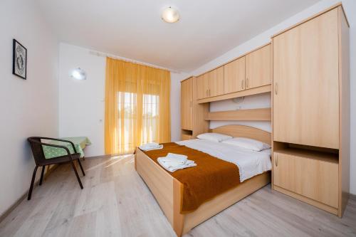 a bedroom with a large bed and a chair at Mladenka in Banjol