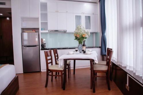 a kitchen with a table with chairs and a refrigerator at SALA HOTEL MÓNG CÁI in Móng Cái
