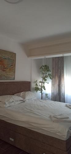 een slaapkamer met een groot bed en een raam bij Apartmani Nikšić Bonaca u Centru in Nikšić