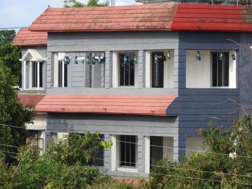 a house with a red roof at Lake Side Resort Neermahal in Melāghar