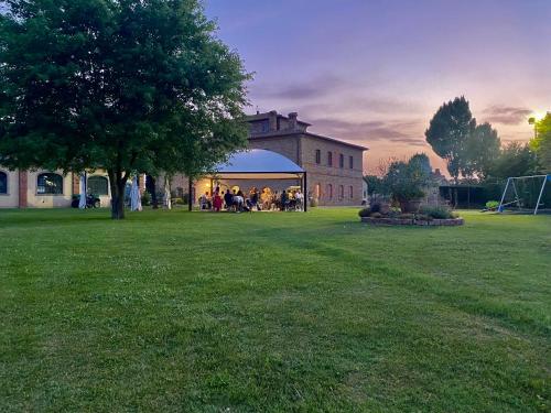 a group of people sitting in a gazebo in a yard at Agriturismo La Colmata in Cesa