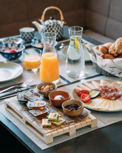 a table with breakfast foods and orange juice on it at Guest House Pohorska Kavarna in Maribor