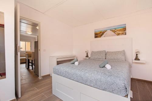 Un dormitorio blanco con una cama y una chimenea. en Apartamento Dayely, en Corralejo