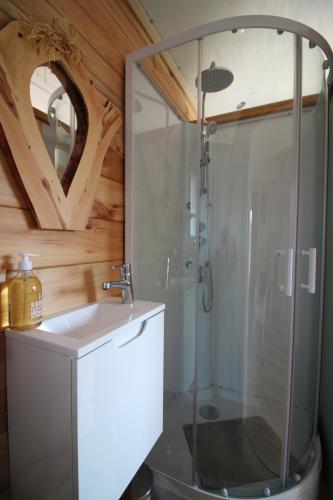 une salle de bain avec douche et lavabo dans l'établissement roulotte impériale perchée-, à Sembadel