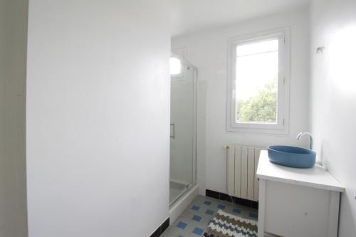ein Badezimmer mit einem blauen Waschbecken und einem Fenster in der Unterkunft L'hermoyse Cosy centre ville in La Selle-en-Hermoy