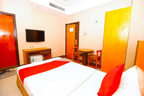 a bedroom with a bed and a table and a television at Sea Shell Hotel in Manama