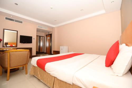 a bedroom with a large bed and a desk at Sea Shell Hotel in Manama