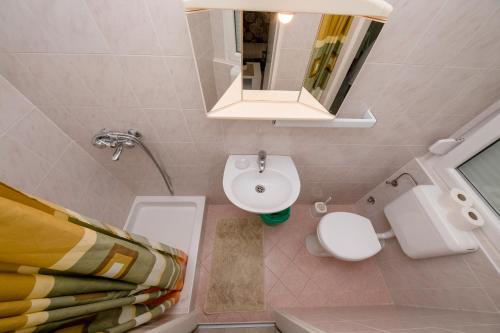 a bathroom with a sink and a toilet and a mirror at Mladenka in Banjol