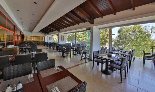 a dining room with tables and chairs and windows at Kaliakra Beach Hotel - Ultra All Inclusive in Albena