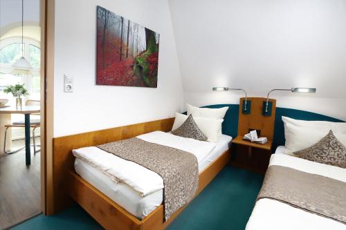 Zimmer mit 2 Betten und einem Tisch mit Tisch in der Unterkunft Parkhotel Flora in Bad Grund