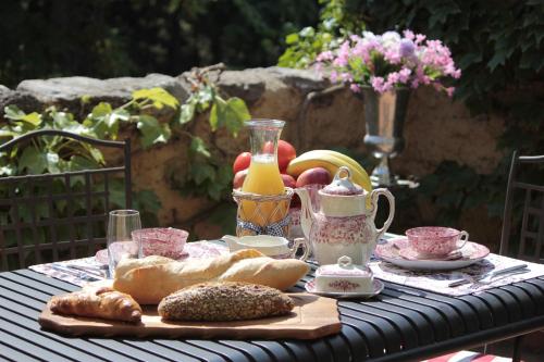 a table with bread and a jug of juice and a plate of food at Masia Mimosa in Darnius