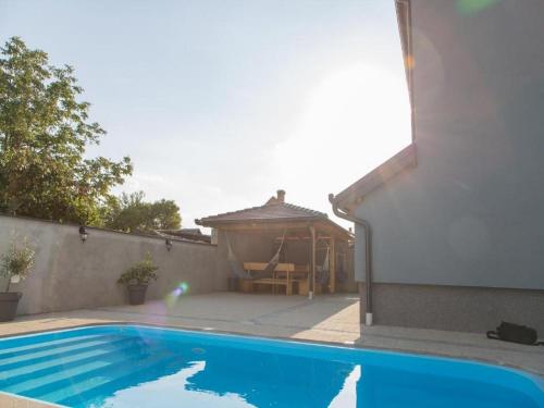 a swimming pool in a backyard with a gazebo at Holiday Home Thesaurum in Karanac